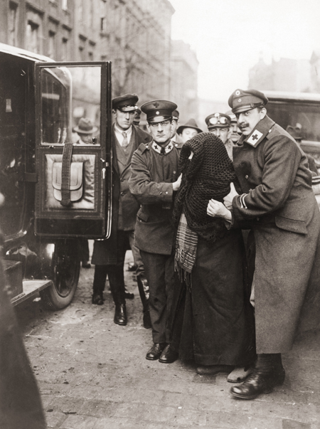 Angehörige des Roten Kreuzes helfen einer älteren Frau zur Volksabstimmung in Oberschlesien (20. März 1921)