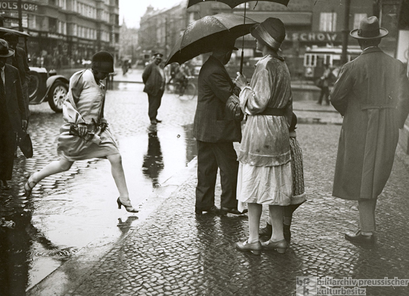 Eine junge Frau springt über eine Pfütze (1930)