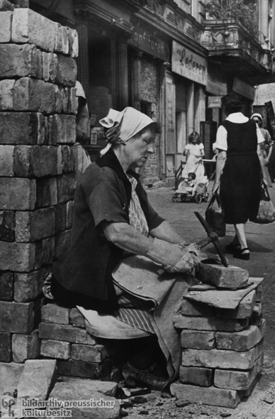 Jeder Stein wird gebraucht: Trümmerfrau beseitigt Mörtelreste (1946)
